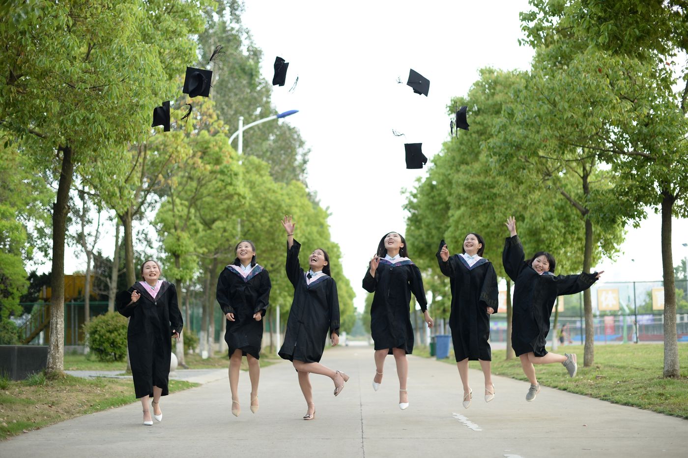 Graduates tossing caps in the air at a sunny end-of-year celebration